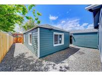 Charming detached home featuring teal siding, white trim, and a gravel yard at 1437 N Uinta St, Denver, CO 80220