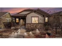 Charming home exterior with stone accents, a cozy front porch and walkway lights under a beautiful sky at 4318 Fossil Way, Castle Rock, CO 80109