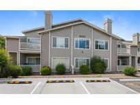 Exterior view of a two-story condo featuring balconies and a well-maintained landscape at 8437 Thunder Ridge Way # 202, Highlands Ranch, CO 80126