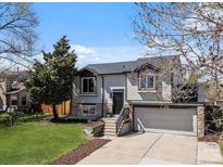 Charming two-story home featuring stone accents, a two-car garage, and a well-maintained front yard at 10895 W Bowles Pl, Littleton, CO 80127