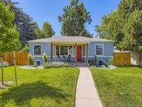 Charming blue home with a red door, a landscaped front yard and cozy porch seating at 1350 E Amherst Ave, Englewood, CO 80113