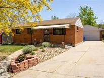 Charming brick home featuring a well-kept front yard and an inviting entrance with awning at 660 Wolff St, Denver, CO 80204