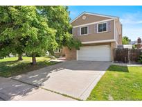 Charming two-story home with a spacious driveway and well-manicured lawn and a two-car garage at 11530 Elm Ct, Thornton, CO 80233