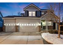 Charming two-story home with a three-car garage and well-lit exterior at 11053 Meadowvale Cir, Highlands Ranch, CO 80130