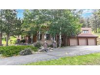 Charming home exterior with mature trees and a three-car garage at 974 Spring Ranch Dr, Golden, CO 80401