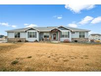 Charming single story home featuring stone accents, blue siding, and a covered front porch at 11177 E 162Nd Pl, Brighton, CO 80602