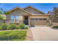 Well-maintained home showcasing a two-car garage and lush lawn at 7845 S Flat Rock Way, Aurora, CO 80016