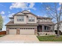 Charming two-story home with a three-car garage and manicured front lawn at 9362 S Holland Way, Littleton, CO 80127
