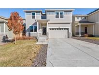 Charming two-story home featuring a two-car garage and a well-manicured lawn at 244 Chipeta Way, Lochbuie, CO 80603