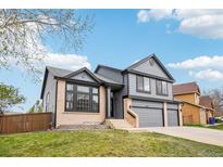 Charming two-story home with gray siding, brick accents, and a well-maintained lawn at 1057 English Sparrow Trl, Highlands Ranch, CO 80129