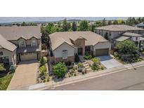 Beautiful home with stone accents, lush landscaping, and a well-manicured lawn at 10994 Shadowbrook Cir, Highlands Ranch, CO 80130