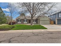 Charming home with a large tree in the front yard, lush green lawn, and a two-car garage at 6376 S Pierson St, Littleton, CO 80127