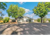 Charming home featuring a driveway, a well-kept lawn, and mature trees surrounding the property at 5385 W 51St Ave, Denver, CO 80212