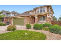 Charming two-story home with a stone facade, lush landscaping, and a well-maintained front yard at 19431 E Wyoming Ave, Aurora, CO 80017