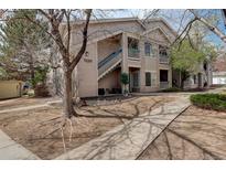 Inviting two-story condo building with blue stair accents, lush landscaping, and a well-maintained walkway at 1120 Opal St # 203, Broomfield, CO 80020