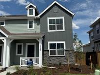 Charming two-story home featuring a covered porch, stone accents, and freshly landscaped front yard at 15238 Detroit St, Thornton, CO 80602