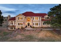Stunning two-story home boasts a red tile roof, grand entrance, and beautifully landscaped front yard at 19185 Breton Pl, Monument, CO 80132