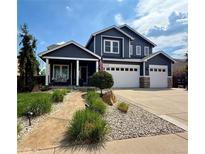 Two-story home featuring an attached three-car garage, well-manicured lawn, and welcoming front porch at 653 Glenarbor Cir, Longmont, CO 80504