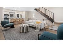 Bright living room with modern staircase, neutral sofa, striped ottoman, and open layout to the kitchen at 4469 Tennyson St # 4, Denver, CO 80212