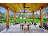Inviting covered patio with wood ceiling, concrete floors, and ample space for dining and entertaining at 3200 Ames St, Wheat Ridge, CO 80212