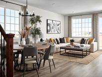 Bright living room featuring modern decor, a comfortable sofa, and large windows offering natural light at 24005 E Utah Pl, Aurora, CO 80018