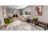 Bright living room features a fireplace, neutral color palette, and wood-look flooring at 8696 E Easter Ave, Centennial, CO 80112