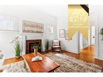 Bright living room with a cozy fireplace, hardwood floors, and stylish decor at 1741 N Emerson St, Denver, CO 80218