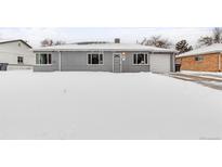 Newly painted house exterior, featuring a snow-covered front yard and attached garage at 881 Salem St, Aurora, CO 80011