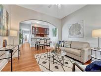 Bright living room features hardwood floors and an open layout leading to the kitchen and dining area at 132 W Bayaud Ave, Denver, CO 80223