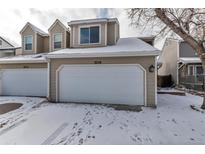 Charming home exterior featuring a two-car garage, snow covered yard, and light tan siding in a desirable location at 3719 S Ensenada St, Aurora, CO 80013