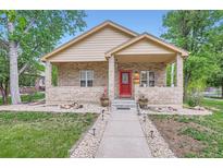 Charming home with brick facade, inviting red door, and landscaped front yard at 218 E Colorado Ave, Berthoud, CO 80513