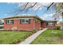 Charming brick home featuring a manicured lawn, quaint walkway, and mature landscaping at 6188 S Westview St, Littleton, CO 80120