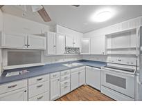 Cozy kitchen with white cabinets, blue countertops and backsplash, and wood-look floors at 350 S Clinton St # 8C, Denver, CO 80247