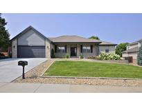 Charming single-story home with a manicured lawn and a two-car garage at 1735 Crestone Dr, Longmont, CO 80504