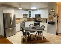 Well-lit kitchen featuring white cabinets and stainless steel appliances, perfect for cooking and entertaining at 645 S Alton Way # 9A, Denver, CO 80247