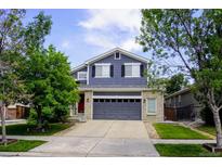 Charming two-story home with a well-manicured lawn, gray painted siding and a two-car garage at 2261 Alpine Dr, Erie, CO 80516