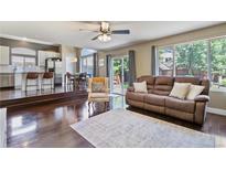 Open concept living area connects to kitchen and dining area; features hardwood floors, comfortable seating, and natural light at 2261 Alpine Dr, Erie, CO 80516