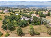 Sprawling property surrounded by lush greenery and trees featuring mountain views, and beautiful landscaping at 6334 Cherokee Dr, Sedalia, CO 80135