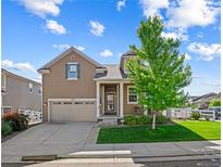 Charming two-story home with a well-manicured front yard and inviting curb appeal at 5230 Periwinkle Way, Henderson, CO 80640