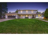 Inviting two-story home with manicured lawn, dark garage door, and a cozy front porch bench at 5853 S Havana Ct, Englewood, CO 80111