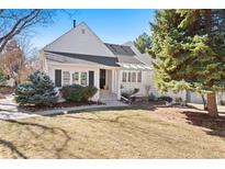 Charming white two-story home with manicured lawn and mature trees on a sunny day at 4505 S Yosemite St # 106, Denver, CO 80237