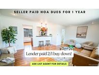 Bright living room with hardwood floors, modern decor, and open kitchen access; seller paid HOA dues for a year at 920 Eudora St # 201, Denver, CO 80220