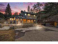 Charming two-story home with stone accents, a spacious driveway and mountain views at sunset at 11531 S Deer Creek Rd, Littleton, CO 80127