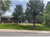 Charming brick home with manicured lawn, mature trees, and a welcoming front porch at 1158 E Easter Ct, Centennial, CO 80122