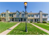 Charming townhomes with individual walkways and lush green lawns on a bright, sunny day at 1622 S Idalia Cir # E, Aurora, CO 80017