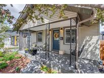 Charming covered front porch with seating area and decorative wrought iron details at 4456 Yates St, Denver, CO 80212