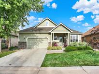Charming home with a well-maintained lawn, stone accents, and attached two-car garage at 11556 W Cooper Pl, Littleton, CO 80127