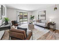 Bright living room featuring stylish furniture, area rug, and sliding glass doors to the outdoors at 7740 W 35Th Ave # 210, Wheat Ridge, CO 80033