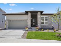 Charming single-story home featuring a well-maintained lawn, brick accents, and an attached two-car garage at 328 Simmental Loop, Castle Rock, CO 80104