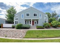 Charming townhome featuring a well-maintained lawn and a welcoming front entrance with red door at 5190 Buckingham Rd, Boulder, CO 80301